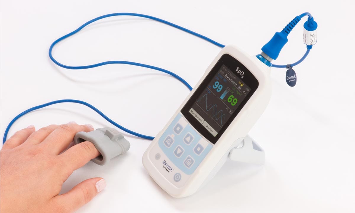 A person uses an electronic device to measure blood pressure.